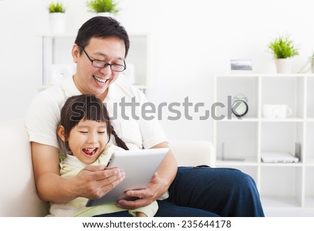 happy father using tablet pc with little girl