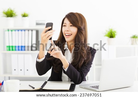 happy business woman using the smart phone in office