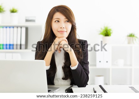 smiling young business woman thinking in the office