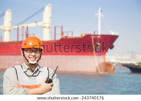 Harbor dock worker holding  radio and  ship background