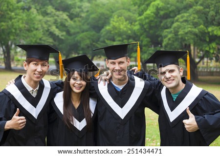 happy students in graduation gowns on university campus