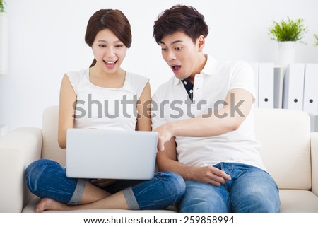 surprised Couple on sofa with laptop computer