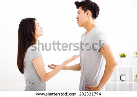Angry young couple arguing in living room
