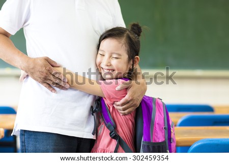 happy little Girl hugging her father in classroom