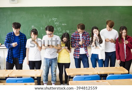 Group of students using smart mobile phones  in classroom