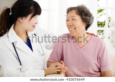 Nurse holding hand of senior woman in rest home