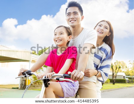 Happy asian family having fun in park with bicycle