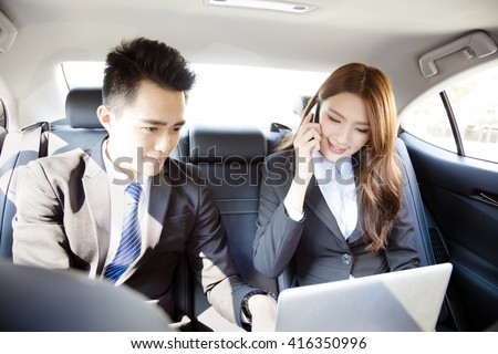 Business man and woman working together in the car