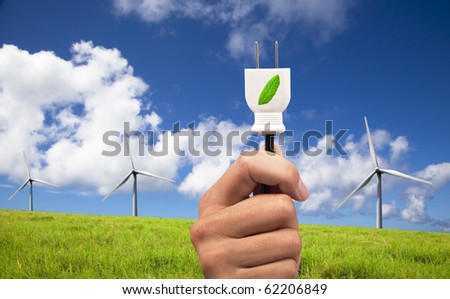 hand hold eco power plug and Wind turbines on blue sky