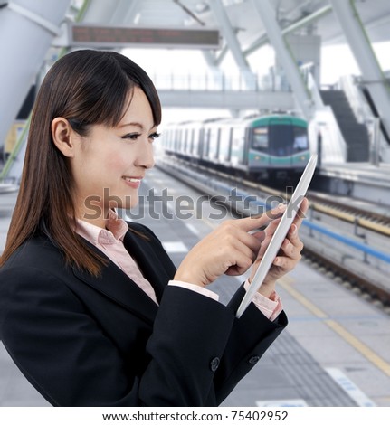 Young business woman using touch pad in the train station