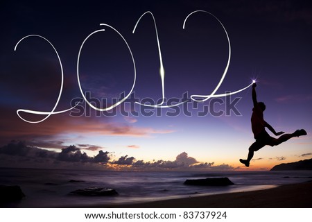 Bonne année 2012 Stock-photo-happy-new-year-young-man-jumping-and-drawing-by-flashlight-in-the-air-on-the-beach-83737924