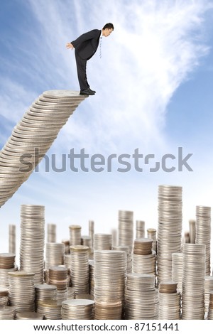 surprised businessman standing on the money stairs and watching many coin towers