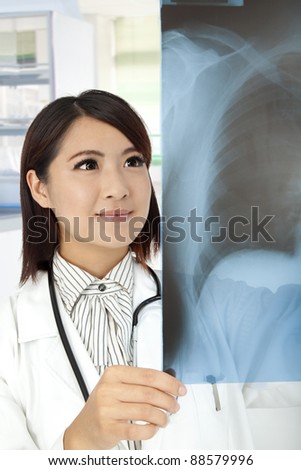 asian Doctor reviewing x-rays in doctor office