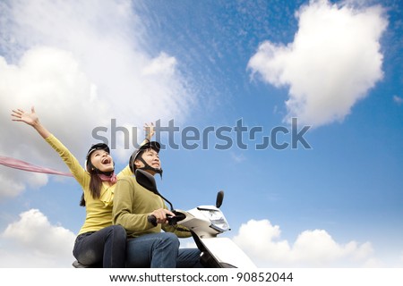 Happy young couple  having fun on a scooter