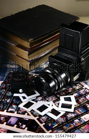 Retro Medium Format Film Camera and Paraphernalia. A photo of a retro medium format film camera with contact sheets, slide films, light meter and books.