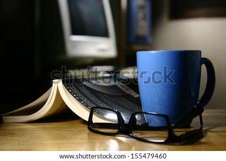 Coffee Break - Computer A photo of a coffee mug, eyeglasses, book, and a computer