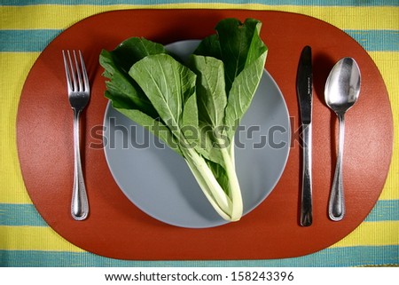 A Pechay or Chinese Cabbage on a Plate A photo of a pechay or chinese cabbage on a plate setting with utensils