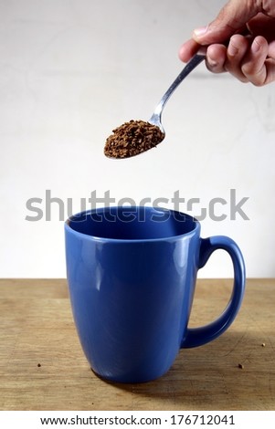 Coffee Being Poured To a Mug Photo of coffee grains being poured to a blue mug.
