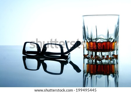 Alcoholic Drink and a pair of eyeglasses Photo of an alcoholic drink in a crystal glass and a pair of eyeglasses