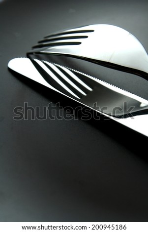 Fork, knife and plate Photo of a silver fork, table knife and a ceramic plate