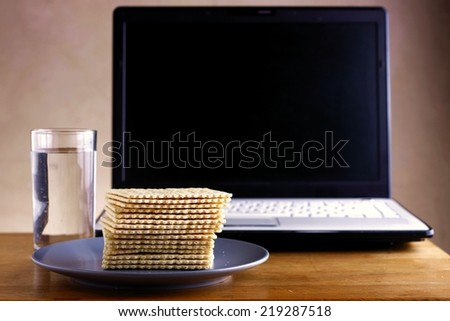 Soda Crackers, Glass of water and a computer Photo of a stack of soda crackers, glass of water and a computer