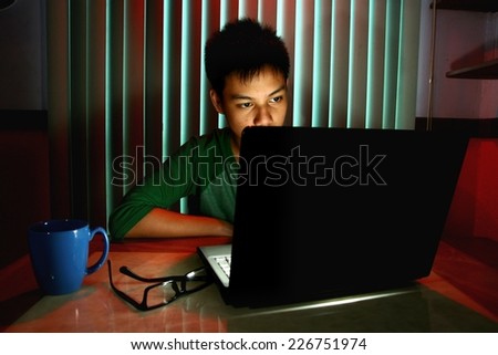 Young Teen with eyeglasses in front of a laptop computer Photo of a Young Teen with eyeglasses in front of a laptop computer