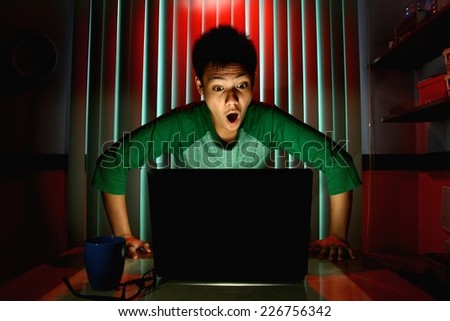Young Teen acting surprised in front of a laptop computer Photo of a Young Teen acting surprised in front of a laptop computer
