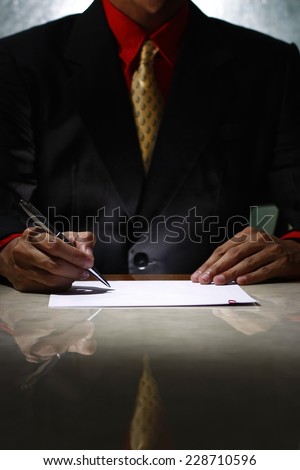 Man writing on a paper Photo of a man writing on a paper or signing on a paper