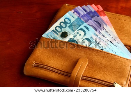 Cash money in a leather wallet Photo of a bunch of cash money in a leather wallet