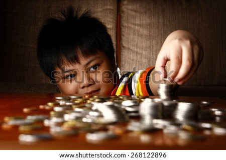 Young Boy Stacking or Piling Coins\
Photo of a young boy stacking or piling coins