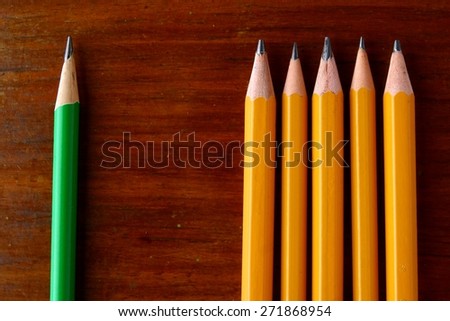 Four yellow pencils and one green pencil Photo of Four yellow pencils and one green pencil