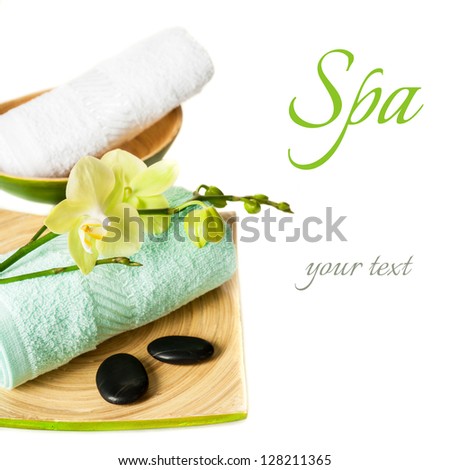 Spa concept: orchid flowers, zen stones and towel on a white background (with sample text)