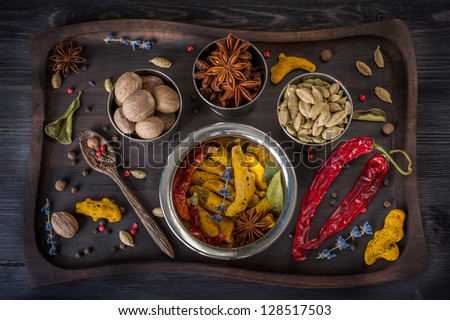 Spices and herbs: star anise, turmeric, nutmeg, cardamom, lavender, allspice and lemon grass in a wooden old tray.