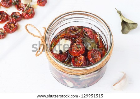 Dried cherry tomatoes with herbs, spices and olive oil. Traditional Italian cuisine.