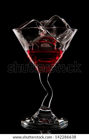 Red cocktail. Liquor, martini or cosmopolitan in a glass on a black background.