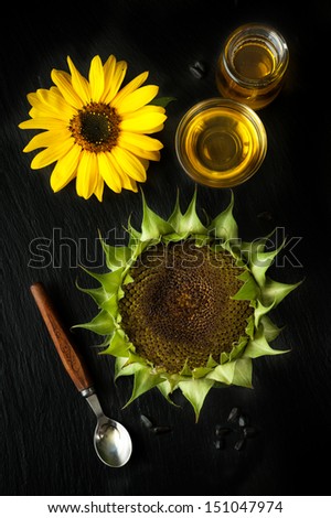 Sunflower oil, sunflower and sunflower seeds on a black chalkboard