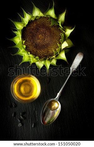 Sunflower oil and sunflower on black chalk board slate