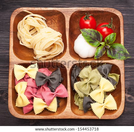 Italian pasta, farfalle, basil and tomatoes in a wooden box