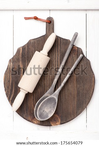 Serving spoons and wooden rolling pin on a vintage board