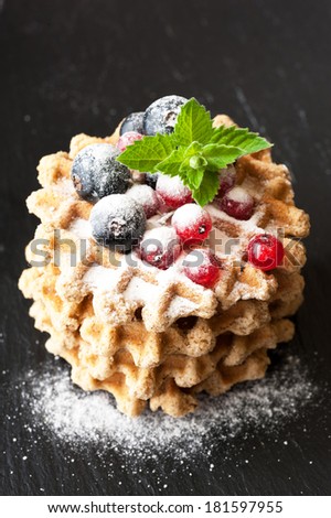 Waffles with berries currants. Chalk board background