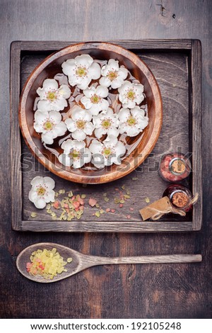Flowers in bowl with water, essential oil and sea salt. Spa.