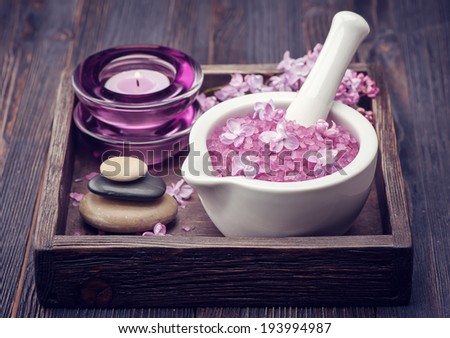 Sea salt in mortar, Zen massage stones and lilac flowers. Spa.