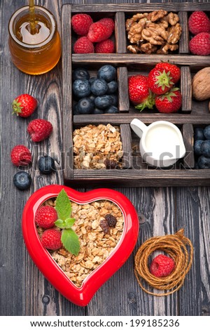Granola muesli with berries, honey, nuts and milk. Concept of healthy food.