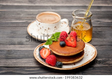 Pancakes, honey, berries and cup coffee espresso