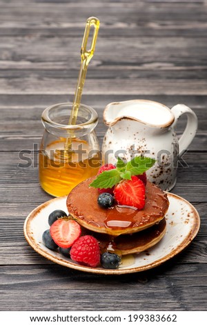 Pancakes, honey, berries and milk. tasty breakfast