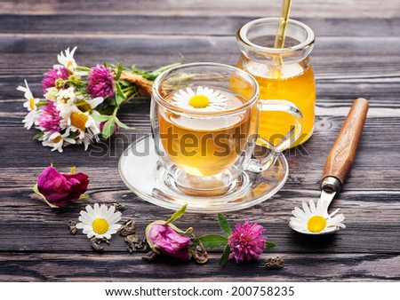 Herbal tea with honey and flowers. Chamomile tea, tea with rose petals and flowers clover.