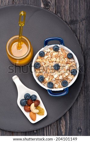 Muesli with raisins, nuts, honey, and blueberries. Fitness breakfast.