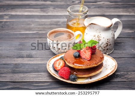 pancakes  with honey and berries, coffee and milk