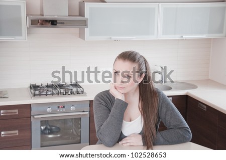 Portrait of beautiful relaxed young woman siting on the kitchen - Indoor