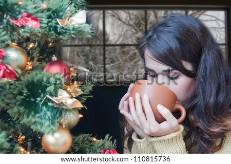 Young woman relaxing at home. Christmas time. Beautiful girl drinking tea at home. Winter day